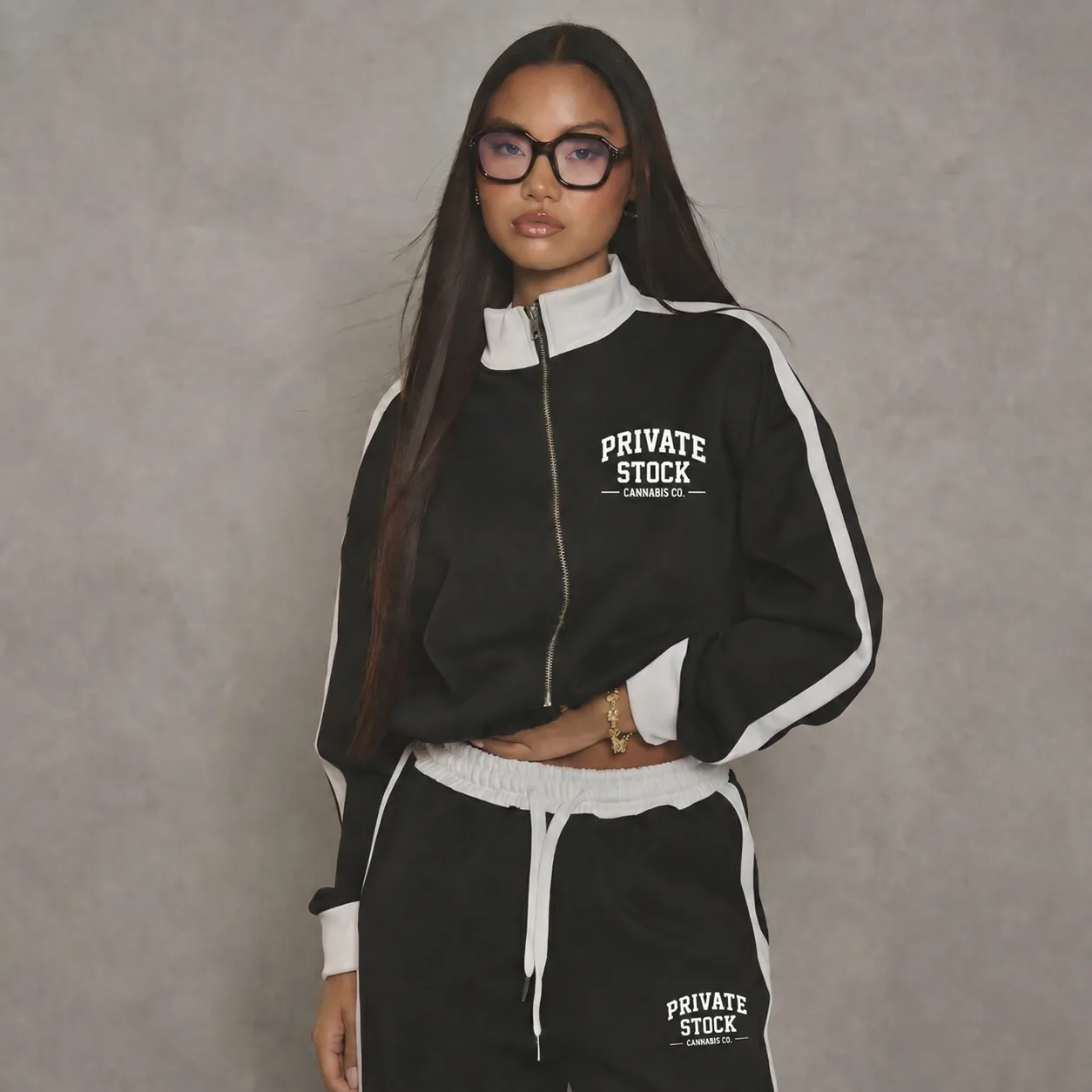 Model wearing the black-and-white Private Stock Cannabis Co. tracksuit